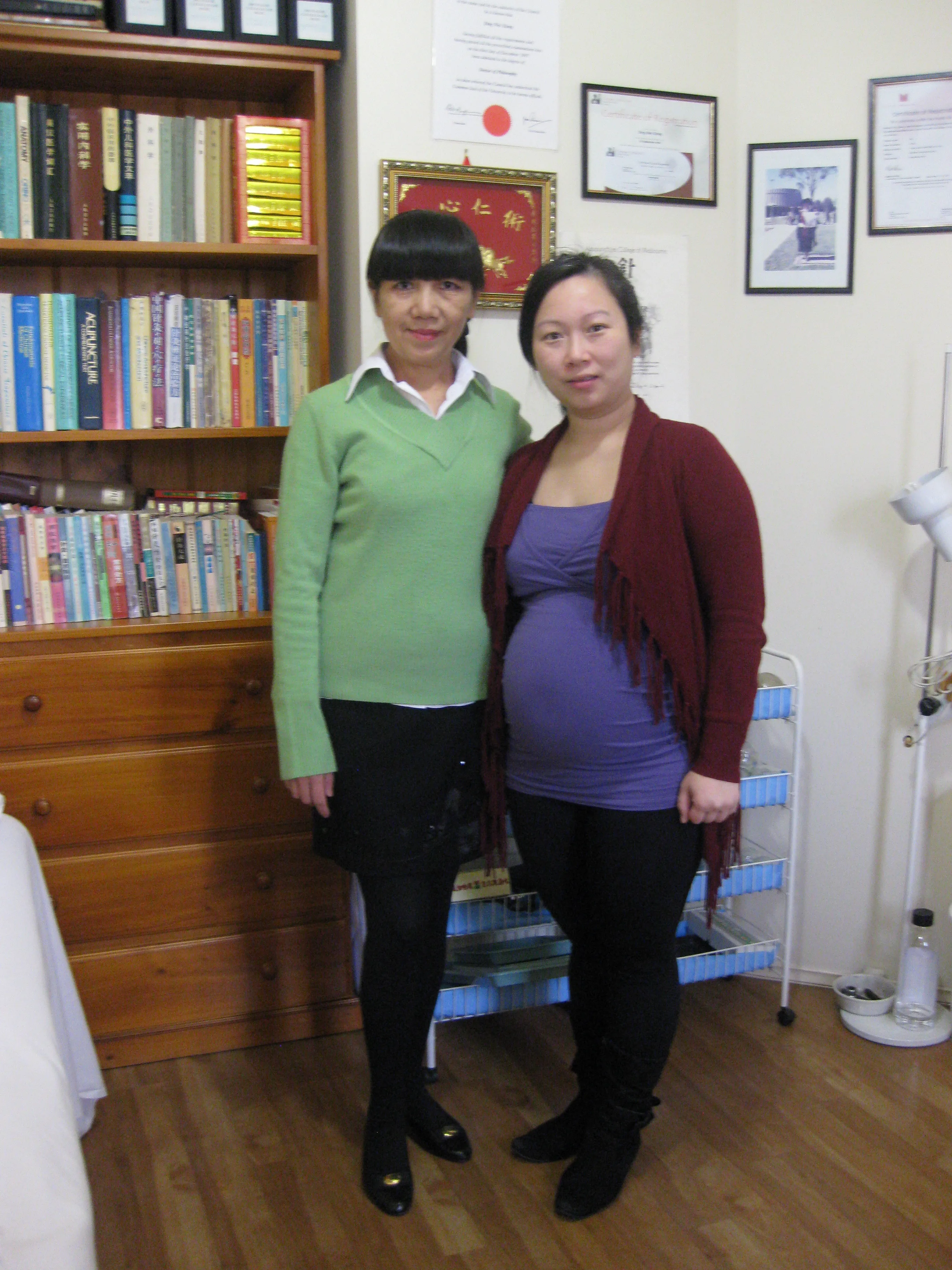 Inside the clinic — Dr. Caroline Xiong with a patient before the TCM reference library